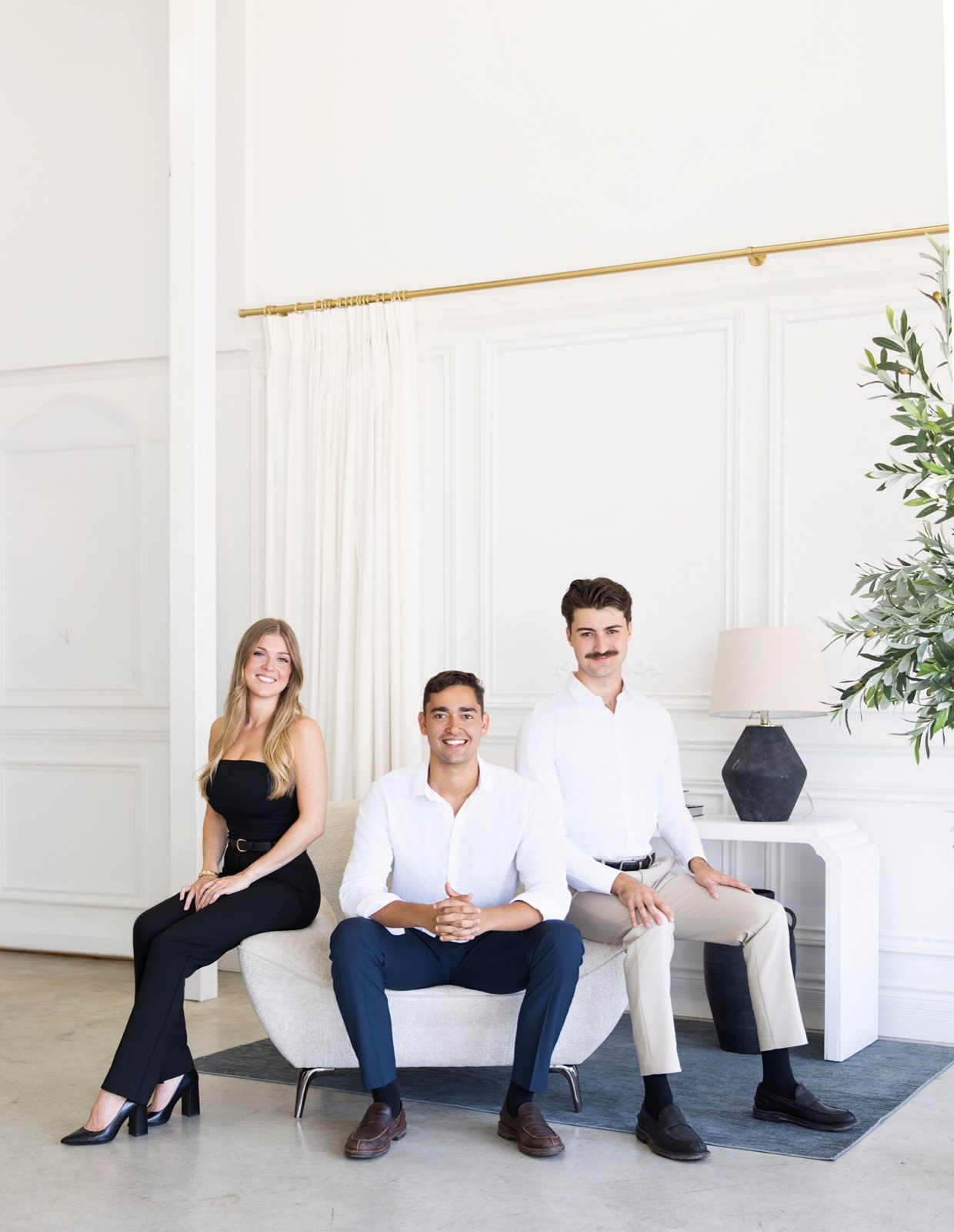 The Groupe Bélanger-Mañon team, three smiling people seated on a sofa in a bright living room